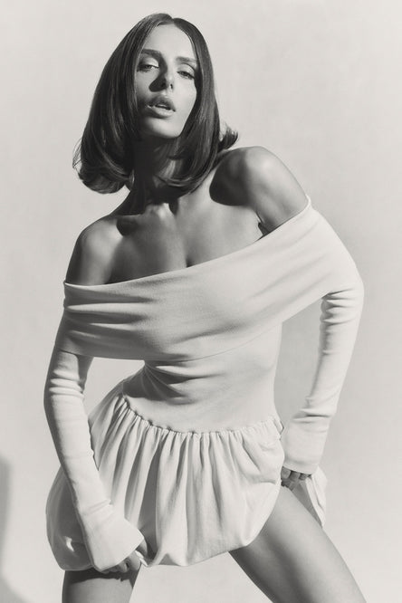 Image of woman in off shoulder knit dress.